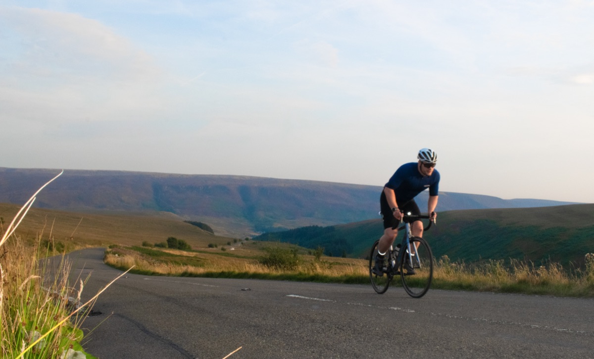 Shea cycling through open hills