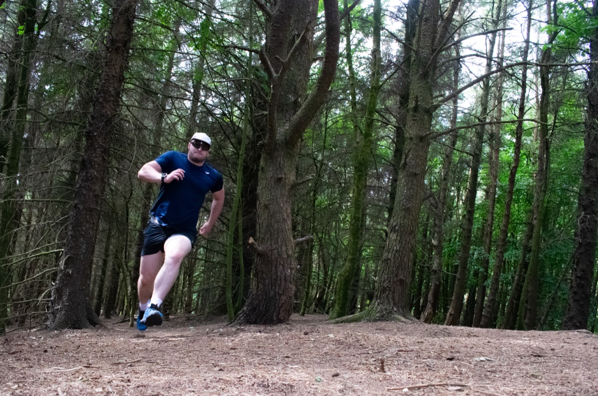 Shea running along a woodland trail