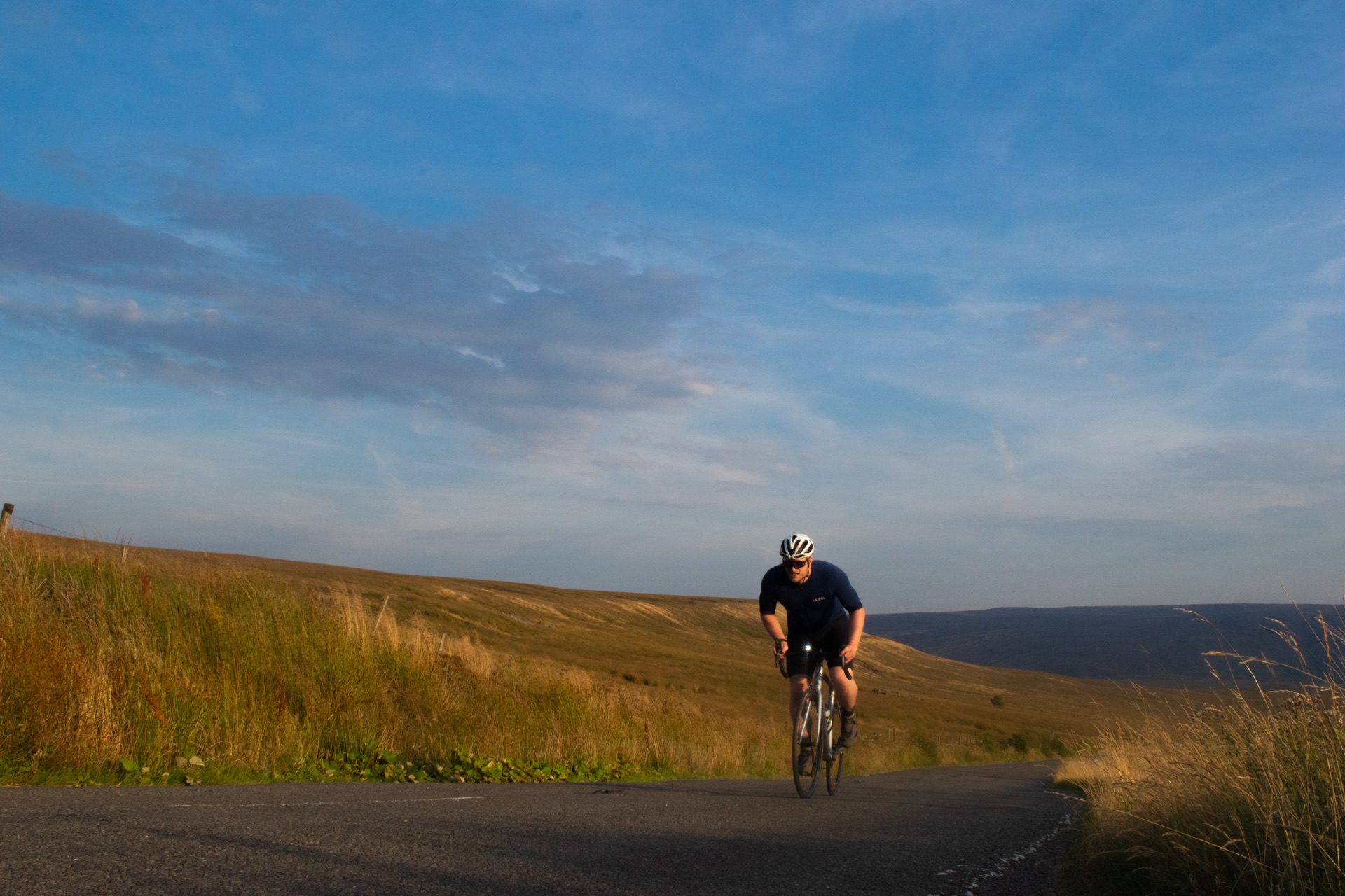 Shea Kerry cycling towards the camera on an open moorland road
